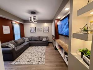 a living room with a couch and a flat screen tv at King Bed In Main Floor - Downtown Vacation Rental in Kalamazoo