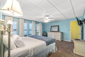 a bedroom with blue walls and a bed and windows at The Treehouse On the Bay in Pensacola Beach