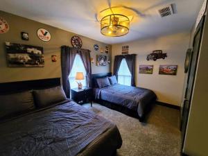 a bedroom with two beds and a chandelier at King Bed In Main Floor - Downtown Vacation Rental in Kalamazoo