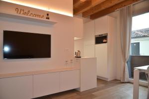 諾阿萊的住宿－CA MATTA luxury and relax，厨房配有白色橱柜和平面电视。