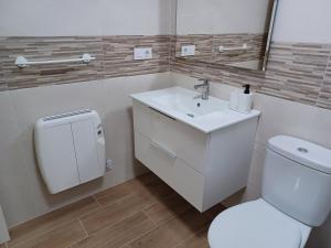 a bathroom with a white toilet and a sink at APARTAMENTO BARLOVENTO in San Vicente de la Barquera +29 photos