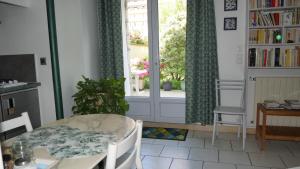 ein Esszimmer mit einem Tisch und einem Fenster in der Unterkunft Gite aux Minimes - Au jardin des alouettes in Toulouse