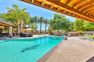 a swimming pool with chairs and palm trees at ScottsdaleandParadise Valley Estate 2 Mi to Old Town in Scottsdale
