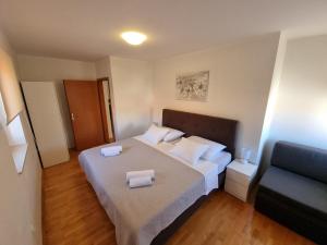 ein Schlafzimmer mit einem großen Bett mit zwei Handtüchern darauf in der Unterkunft Apartments Ivana Rab in Rab
