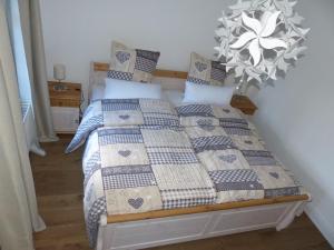 a bed with a blue and white quilt and pillows at Ferienwohnung "Alte Pleiner Mühle" in Plein