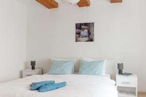 Levendula Apartmanház في باداتشونيتوماي: غرفة نوم بسرير ابيض عليها مخدات زرقاء