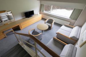 a living room with a couch and a table and chairs at ANA Crowne Plaza Resort Appi Kogen, an IHG Hotel in Hachimantai
