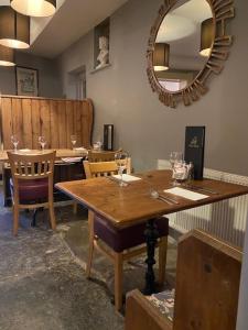 una sala da pranzo con tavolo in legno e specchio di The Ilchester Arms Hotel, Ilchester Somerset a Ilchester