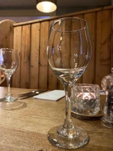 two wine glasses sitting on top of a table at The Ilchester Arms Hotel, Ilchester Somerset in Ilchester