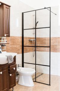 バダチョニトマイにあるLevendula Apartmanházのバスルーム(ガラス張りのシャワー、トイレ、シンク付)
