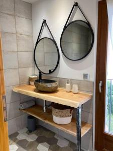 a bathroom with a sink and two mirrors on the wall at Chalet Soubeyran in Guillaumes