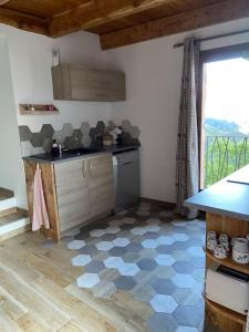 cocina con suelo de baldosa y ventana en Chalet Soubeyran, en Guillaumes