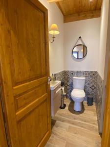 a bathroom with a toilet and a wooden door at Chalet Soubeyran in Guillaumes