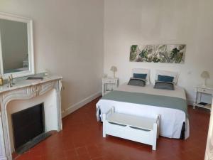 - une chambre blanche avec un lit et une cheminée dans l'établissement Appartement avec balcon, bord du canal, Wifi., à Narbonne