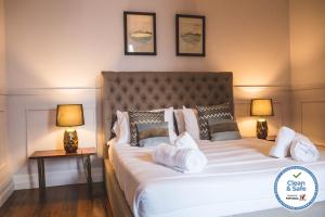 een slaapkamer met een groot wit bed met 2 lampen bij Casa do Vereador in Ponta Delgada