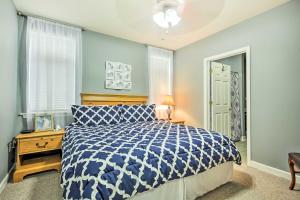 Un dormitorio con una cama azul y blanca y una ventana en Huddleston Condo Rental on Smith Mountain Lake!, en Huddleston