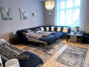 un soggiorno con divano blu e tavolo di Blanka Villa Wellness Home a Bakonyszentlászló