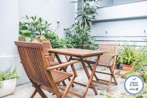 a wooden table and chairs on a patio with plants at Casa do Vereador in Ponta Delgada