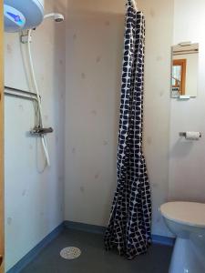 baño con cortina de ducha colgada en la pared en Holzhaus mit überdachter Terrasse, 
