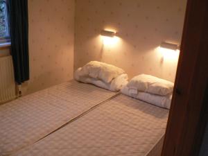 1 dormitorio con 2 camas con sábanas blancas en Holzhaus mit überdachter Terrasse, 