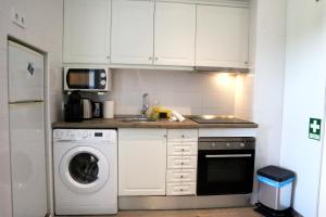 een keuken met een wasmachine en een magnetron bij Alvor Studio 206 in Alvor