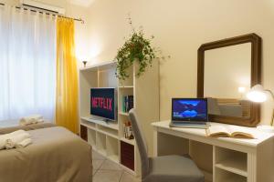 Schlafzimmer mit einem Schreibtisch, einem Laptop und einem Spiegel in der Unterkunft Apartment Il Tettuccio di Valerio in Rom
