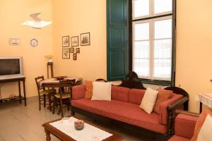 a living room with a red couch and a table at 1861 Mansion Spetses in Spetses