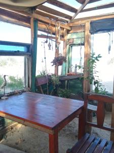 a wooden table in a room with two windows at Para un poquito relax in Barra de Valizas