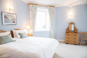 a bedroom with a large white bed and a window at Kingswear Park Club in Kingswear