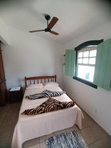 een slaapkamer met 2 bedden en een plafondventilator bij Hospedagem da Val in Paraty
