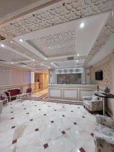 a lobby with a large room with a tv and chairs at MUGHAN PARK HOTEL in Sabirabad