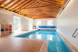 a swimming pool in a home with a wooden ceiling at Kingswear Park Club in Kingswear