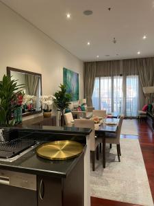 un salon avec une cuisine et une salle à manger dans l'établissement Luxury 1BR apartment in Anantara Hotel Palm Jumeirah connected Anantara Hotel, à Dubaï
