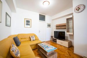 uma sala de estar com um sofá e uma televisão em Apartment Suzy em Zadar