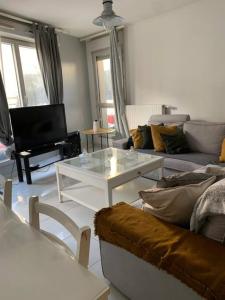sala de estar con sofá y mesa de centro en Appartement moderne et spacieux proche Paris, en Alfortville