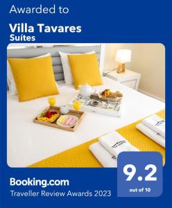 ein Hotelzimmer mit einem Tablett mit Essen auf dem Bett in der Unterkunft Villa Tavares Suítes in Arouca