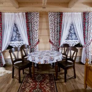 comedor con mesa, sillas y cortinas en U Huraja en Groń