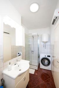 uma casa de banho com um lavatório e uma máquina de lavar roupa em Apartment Suzy em Zadar