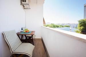 uma varanda com uma mesa, uma cadeira e uma janela em Apartment Suzy em Zadar