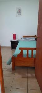 1 dormitorio con cama de madera con sábanas azules en MyR alojamientos 2 en Ushuaia