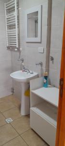 Baño blanco con lavabo y espejo en MyR alojamientos 2 en Ushuaia