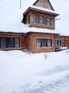 una cabaña de madera en la nieve en U Huraja en Groń