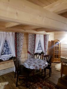 a dining room with a table and chairs and windows at U Huraja in Groń +14 photos