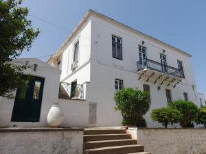 ein weißes Haus mit einer Treppe davor in der Unterkunft 1861 Mansion Spetses in Spetses