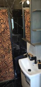 a bathroom with a sink and a zebra print wall at Haus am See in Biersdorf am See