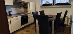 een keuken met een tafel en stoelen en een keuken met een fornuis bij Haus am See in Biersdorf