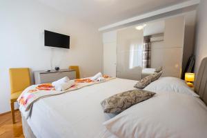um quarto com duas camas e uma televisão na parede em Apartment Suzy em Zadar