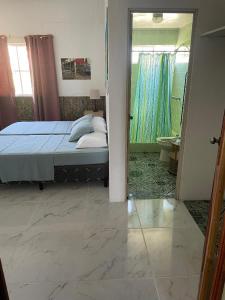 a bedroom with a bed and a bathroom with a mirror at Playa El Obipo C La Marea building La Libertad in La Libertad