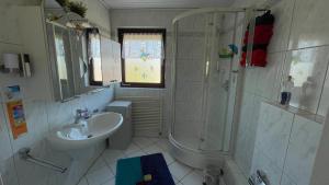 a white bathroom with a sink and a shower at Ferienwohnung Nordlichter Bremerhaven in Bremerhaven