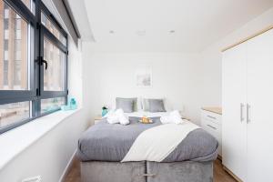 a bedroom with a bed and a window at Cresta House - Modern Apartments in Luton
